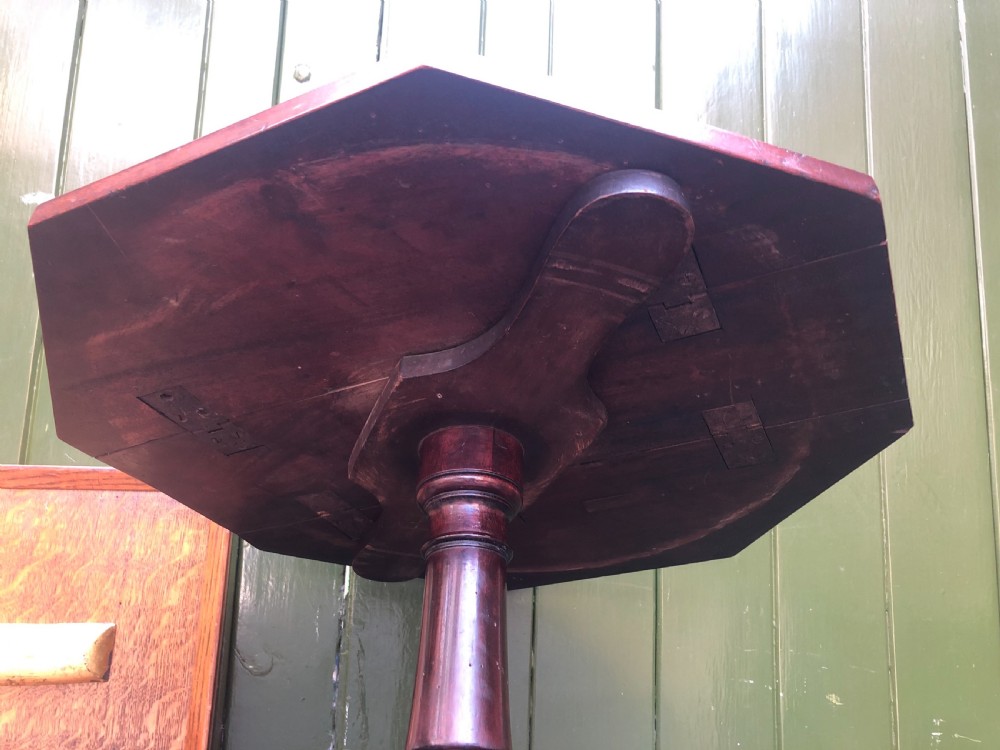 A late eighteenth-century George III mahogany two-tier dumb waiter table featuring octagonal drop-leaf surfaces supported by a turned central column on tripod legs with brass castors. View XIX