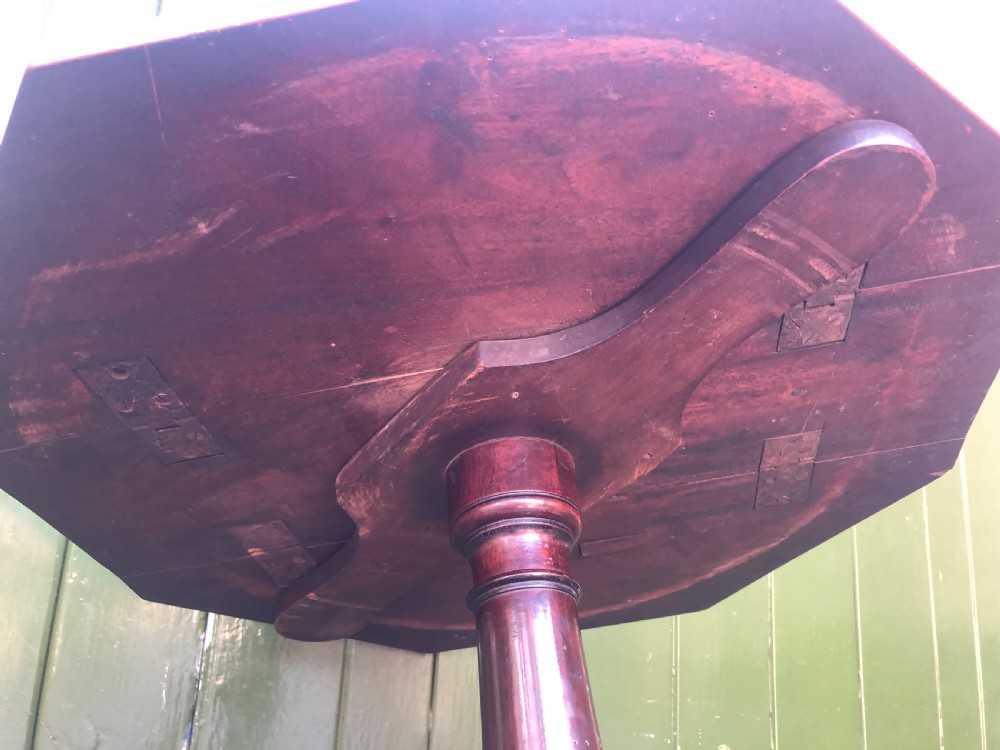 A late eighteenth-century George III mahogany two-tier dumb waiter table featuring octagonal drop-leaf surfaces supported by a turned central column on tripod legs with brass castors. View XXII