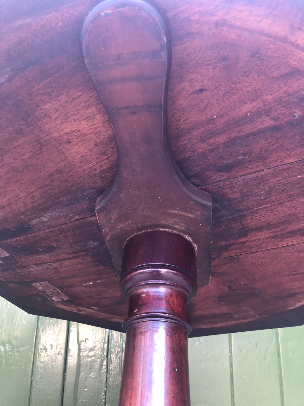 A late eighteenth-century George III mahogany two-tier dumb waiter table featuring octagonal drop-leaf surfaces supported by a turned central column on tripod legs with brass castors. View XXIV