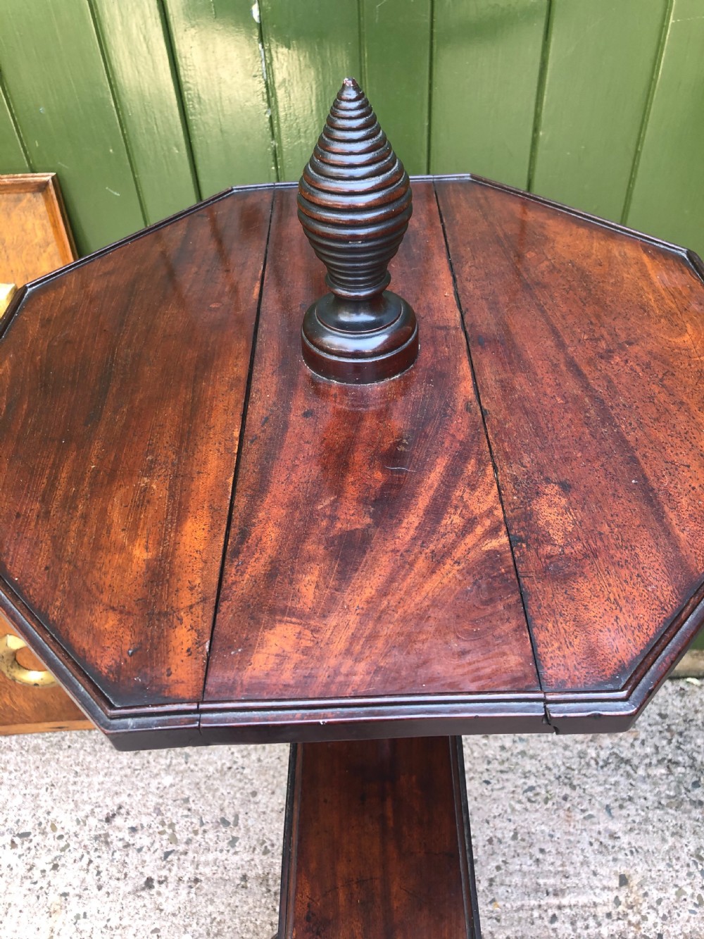 A late eighteenth-century George III mahogany two-tier dumb waiter table featuring octagonal drop-leaf surfaces supported by a turned central column on tripod legs with brass castors. View XXV