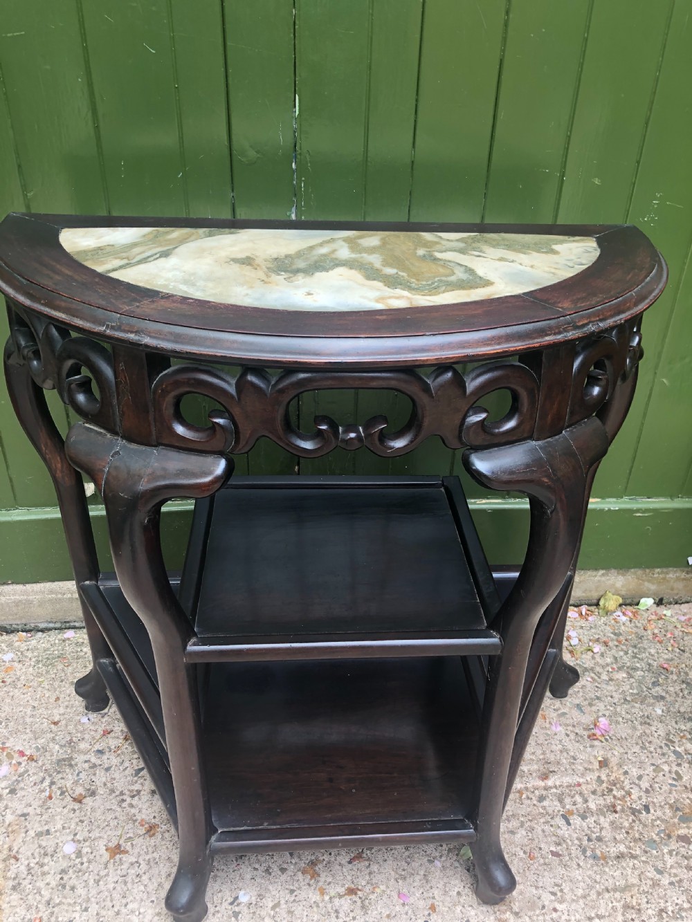 A 19th-century Chinese dark hardwood demi-lune console table featuring an inset variegated marble top, openwork carved frieze, and lower tier shelving. View III