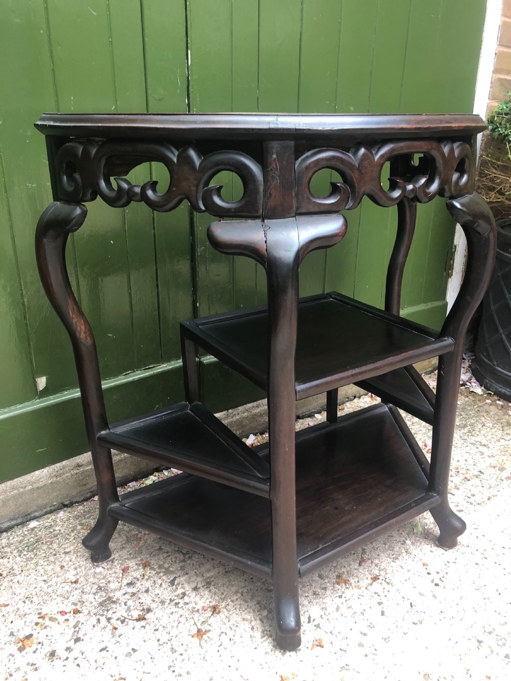 A 19th-century Chinese dark hardwood demi-lune console table featuring an inset variegated marble top, openwork carved frieze, and lower tier shelving. View IV
