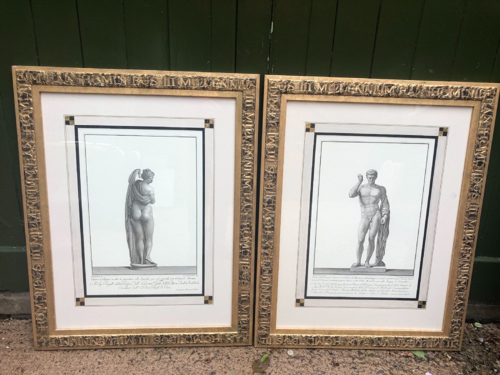 A pair of framed late 18th-century Neoclassical engravings depicting classical Greco-Roman statues in gilded wooden frames.