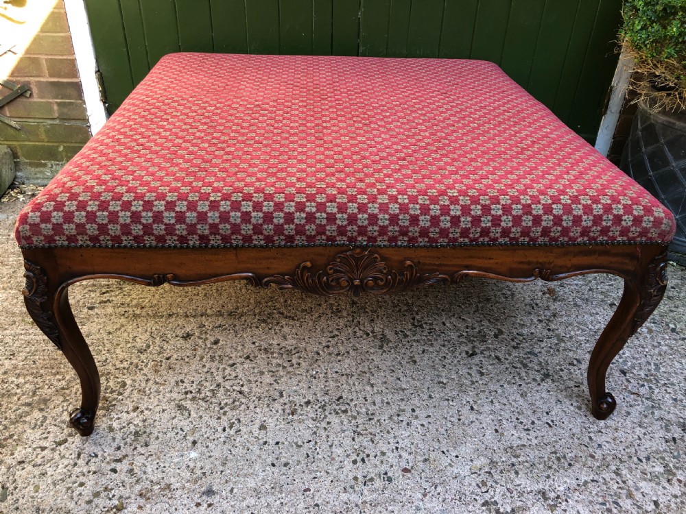 Large early C20th carved walnut-framed upholstered stool of mid C19th design.