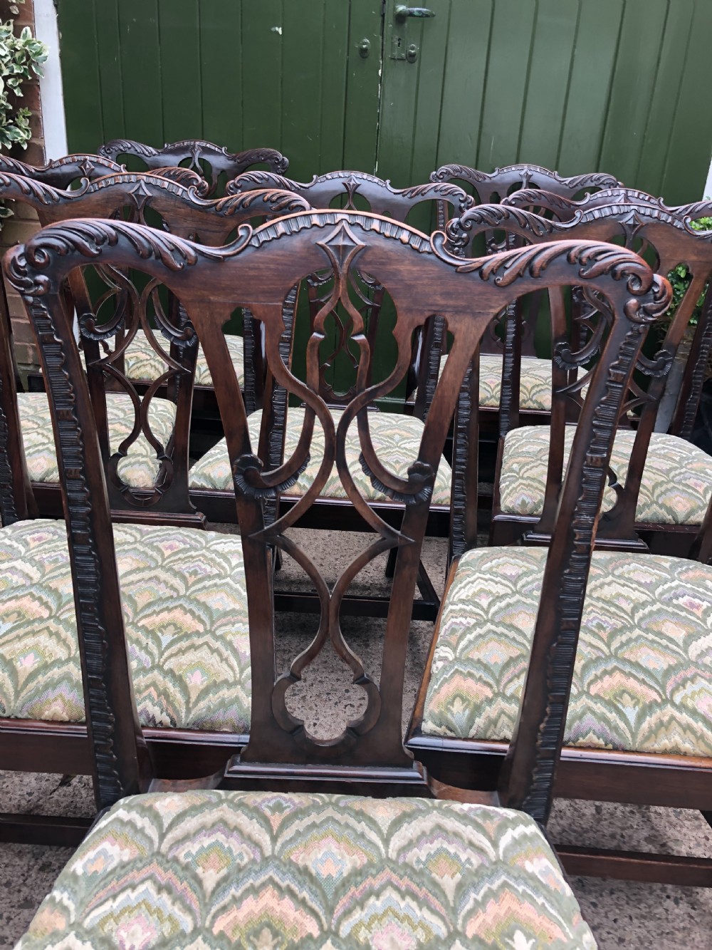 A set of eight carved mahogany Chippendale style dining chairs with decorative pierced back splats and patterned upholstered seats. View II