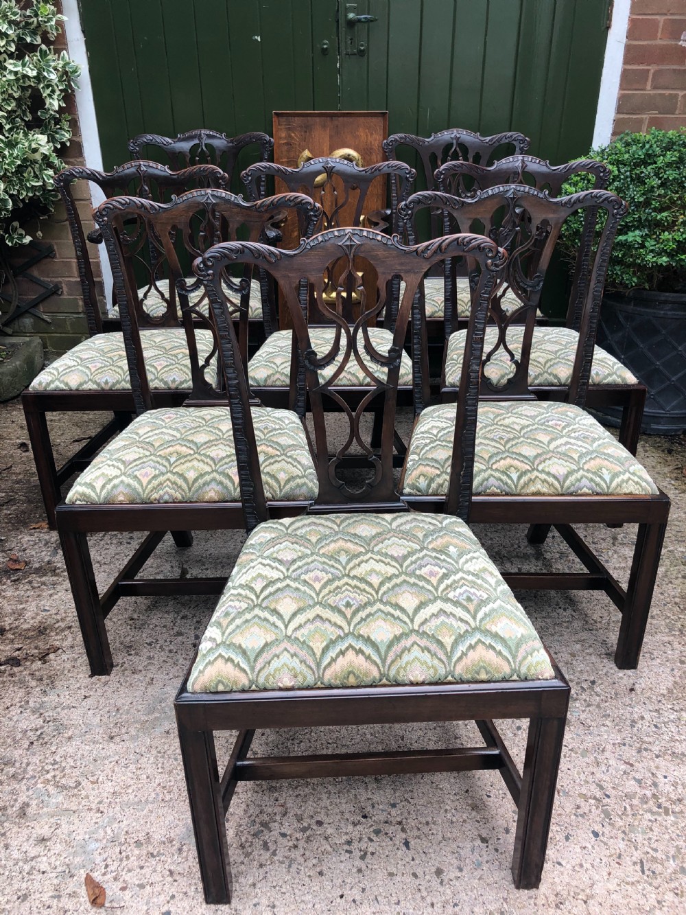 A set of eight carved mahogany Chippendale style dining chairs with decorative pierced back splats and patterned upholstered seats. View III