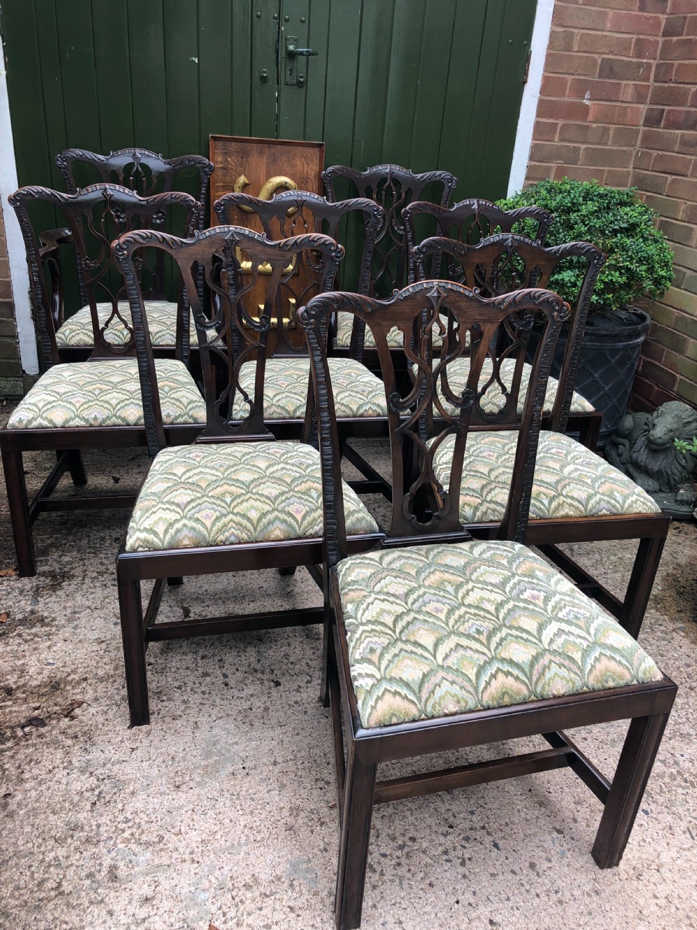 A set of eight carved mahogany Chippendale style dining chairs with decorative pierced back splats and patterned upholstered seats. View IV