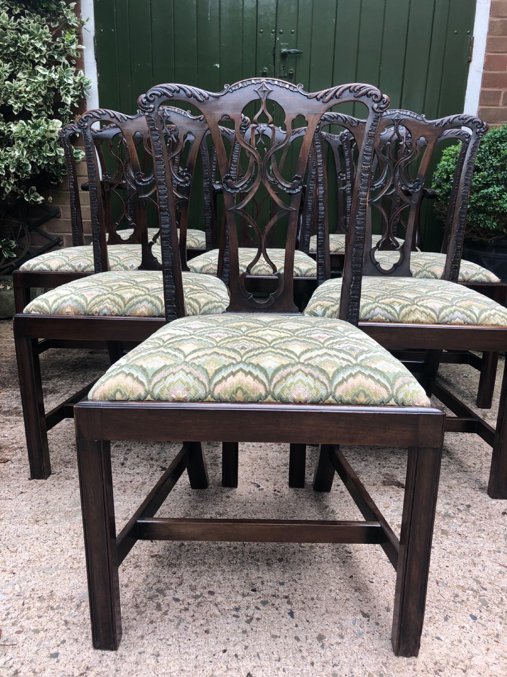 A set of eight carved mahogany Chippendale style dining chairs with decorative pierced back splats and patterned upholstered seats. View VIII