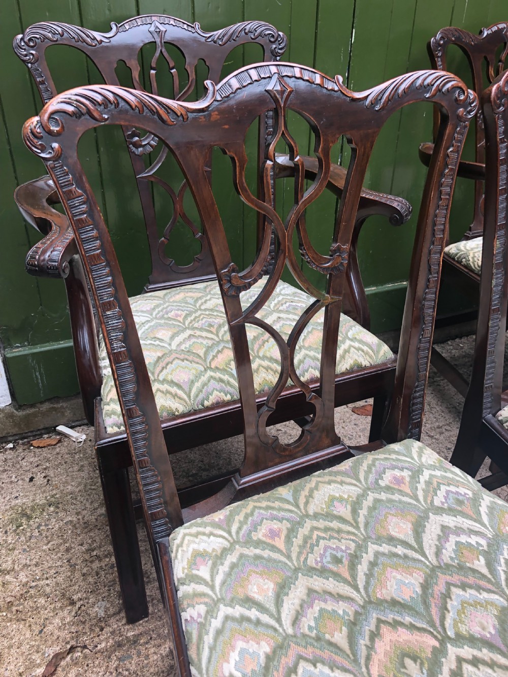 A set of eight carved mahogany Chippendale style dining chairs with decorative pierced back splats and patterned upholstered seats. View X