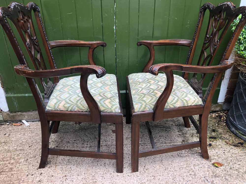 A set of eight carved mahogany Chippendale style dining chairs with decorative pierced back splats and patterned upholstered seats. View XVI