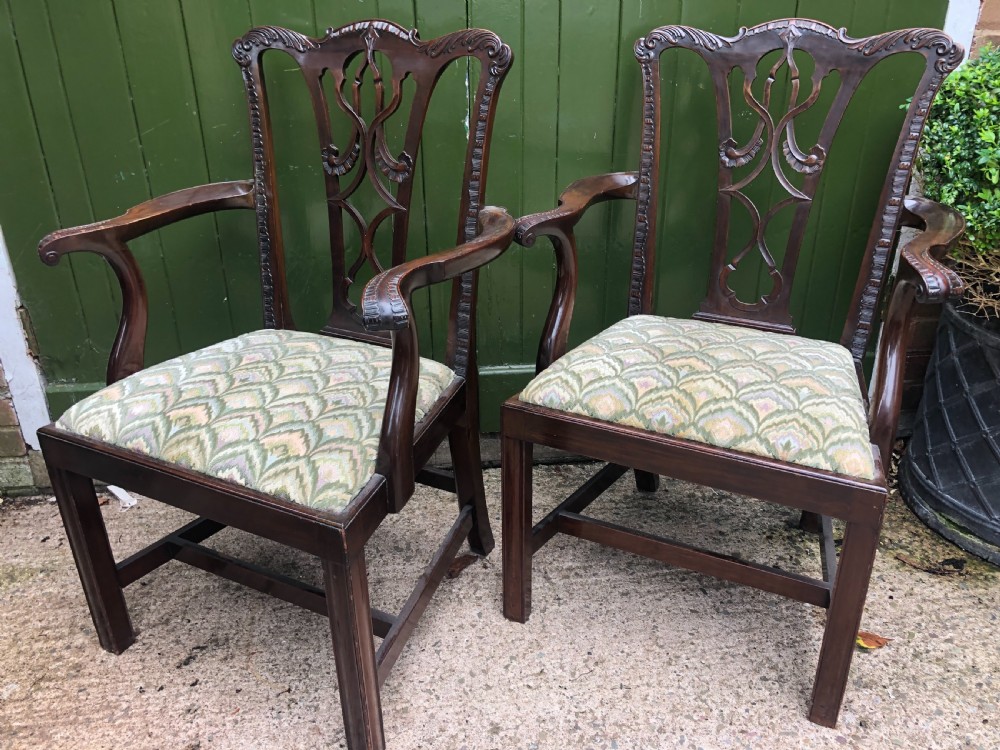 A set of eight carved mahogany Chippendale style dining chairs with decorative pierced back splats and patterned upholstered seats. View XVIII