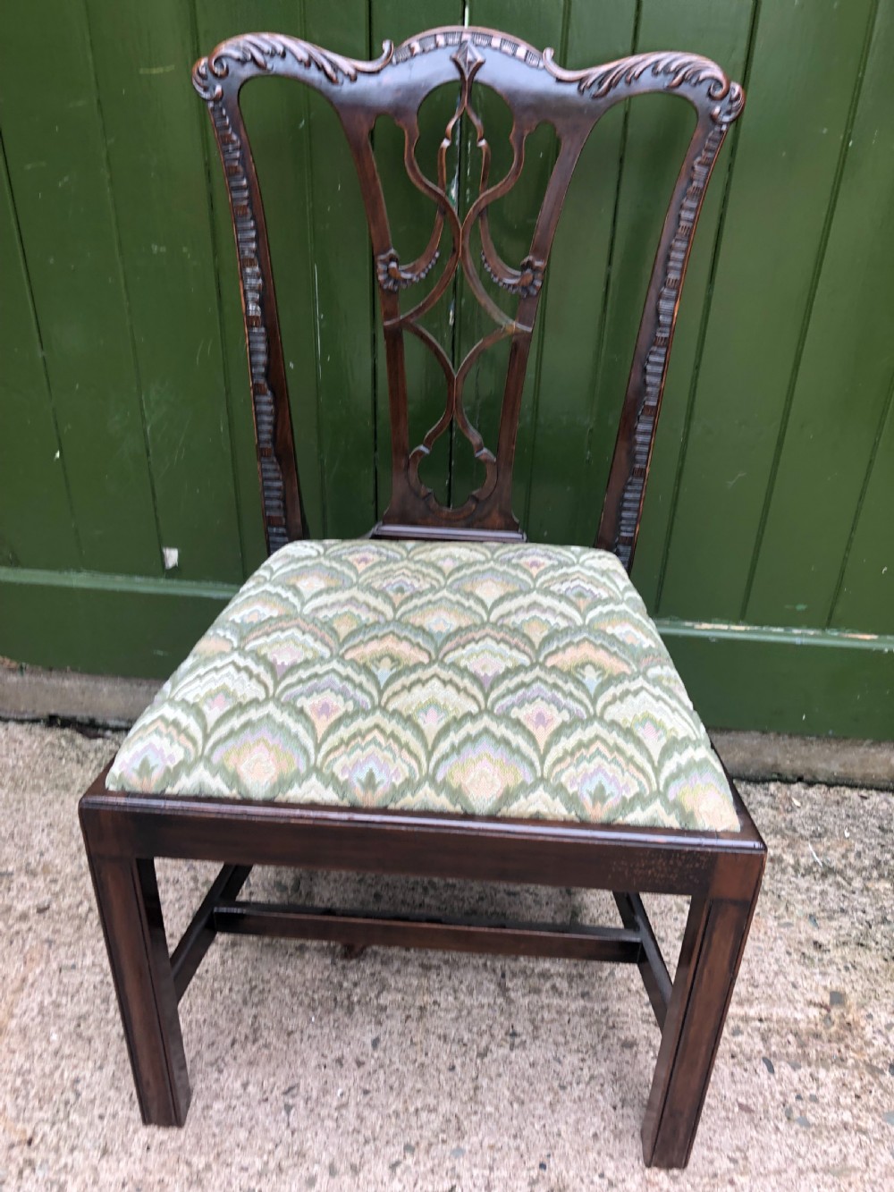 A set of eight carved mahogany Chippendale style dining chairs with decorative pierced back splats and patterned upholstered seats. View XX