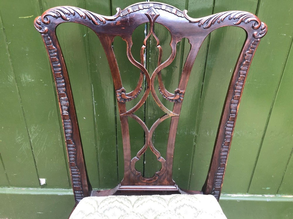 A set of eight carved mahogany Chippendale style dining chairs with decorative pierced back splats and patterned upholstered seats. View XXI