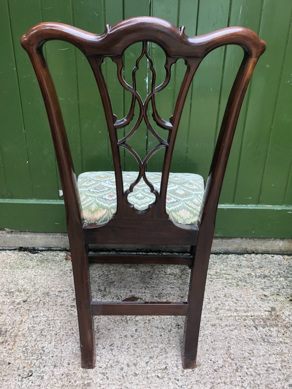 A set of eight carved mahogany Chippendale style dining chairs with decorative pierced back splats and patterned upholstered seats. View XXV