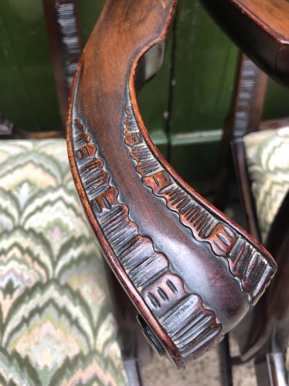 A set of eight carved mahogany Chippendale style dining chairs with decorative pierced back splats and patterned upholstered seats. View XXVII