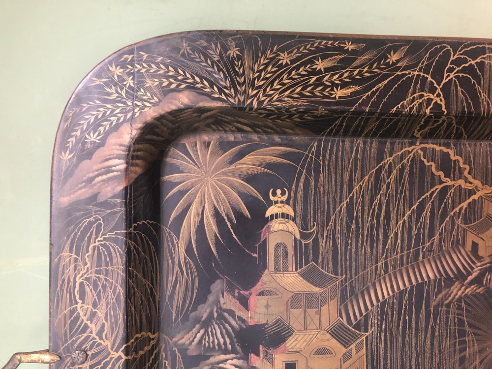 A rectangular black lacquered Regency papier-mache tray featuring gilded chinoiserie landscape decoration and two brass side handles. View III