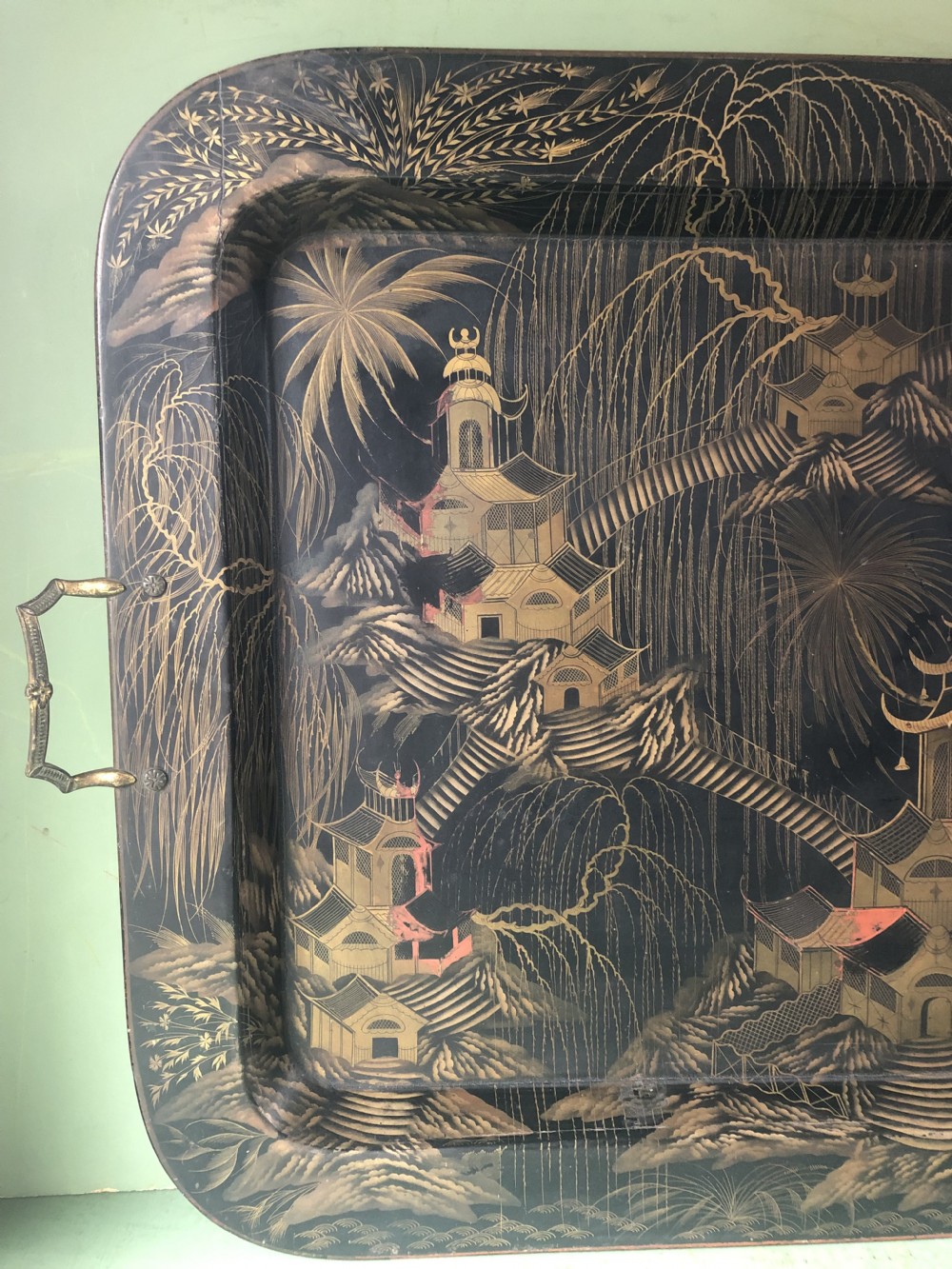 A rectangular black lacquered Regency papier-mache tray featuring gilded chinoiserie landscape decoration and two brass side handles. View XIII
