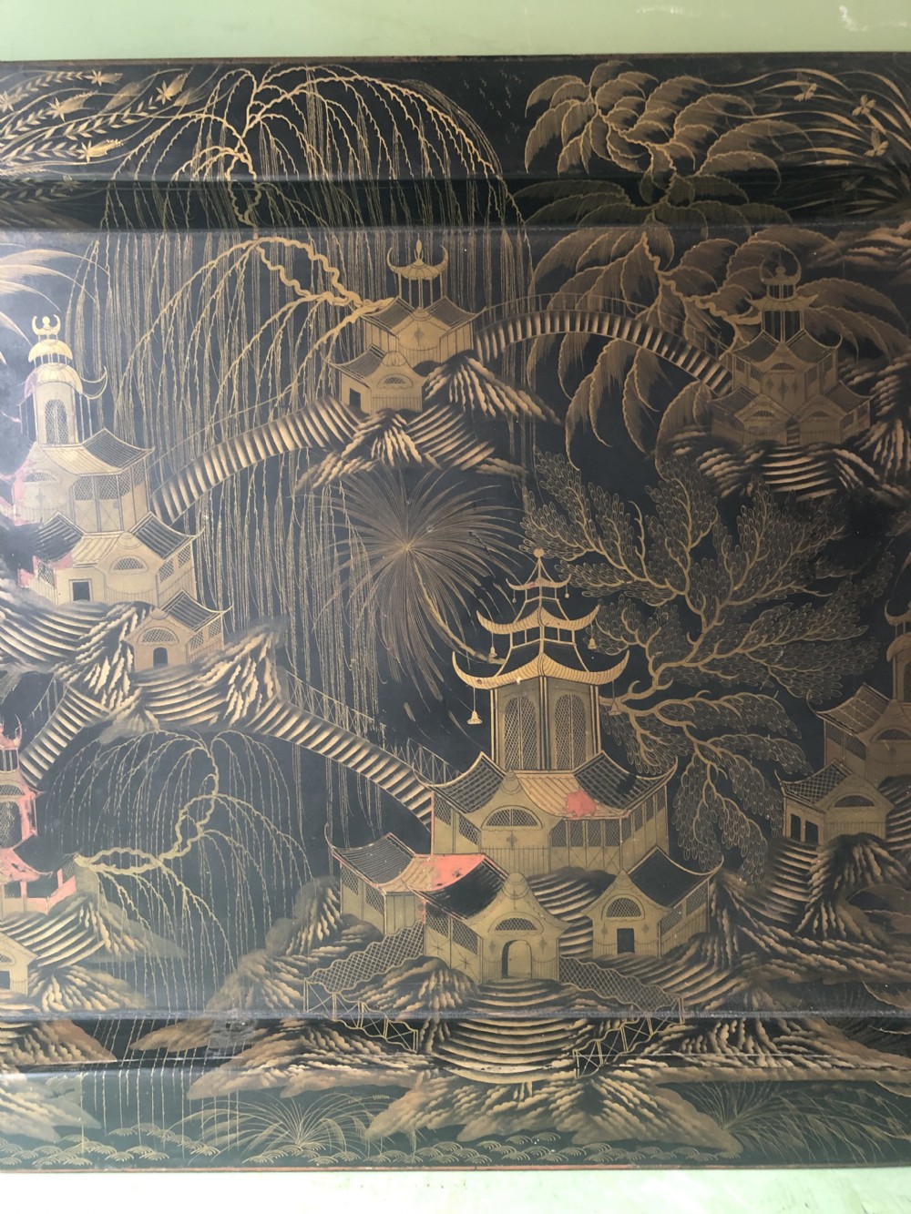 A rectangular black lacquered Regency papier-mache tray featuring gilded chinoiserie landscape decoration and two brass side handles. View XIV