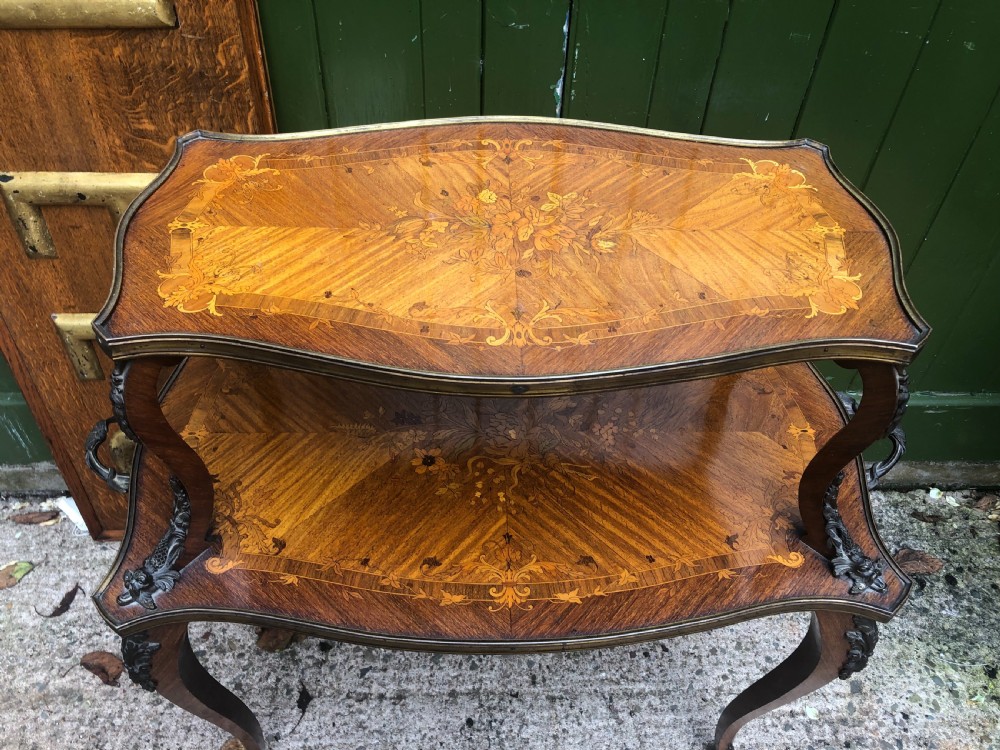 An early nineteenth-century French two-tier etagere table featuring detailed floral marquetry inlay, cabriole legs, brass galleries, and metal side handles. View II