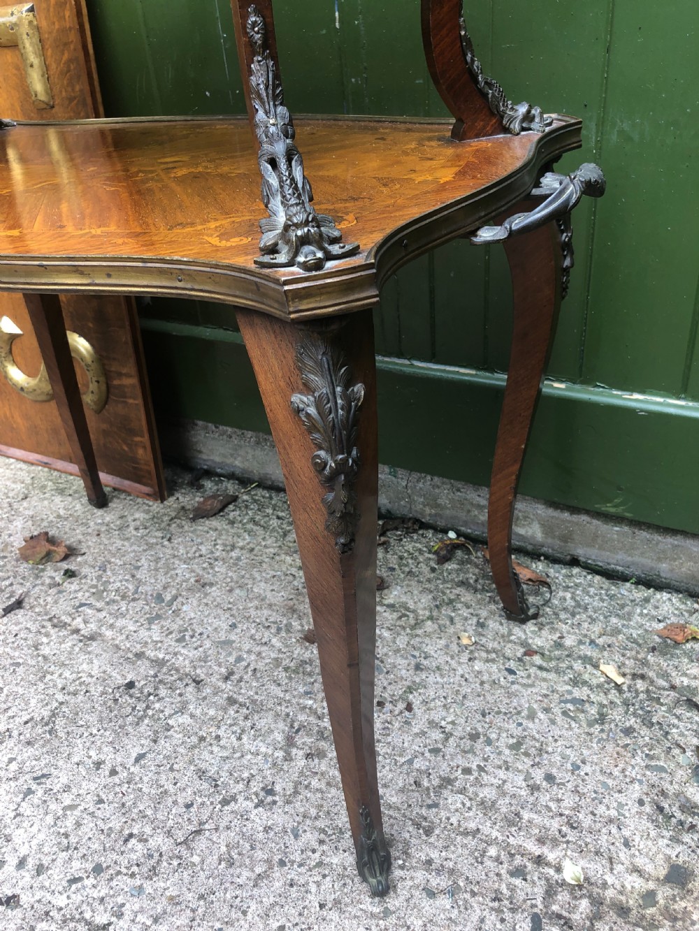 An early nineteenth-century French two-tier etagere table featuring detailed floral marquetry inlay, cabriole legs, brass galleries, and metal side handles. View III