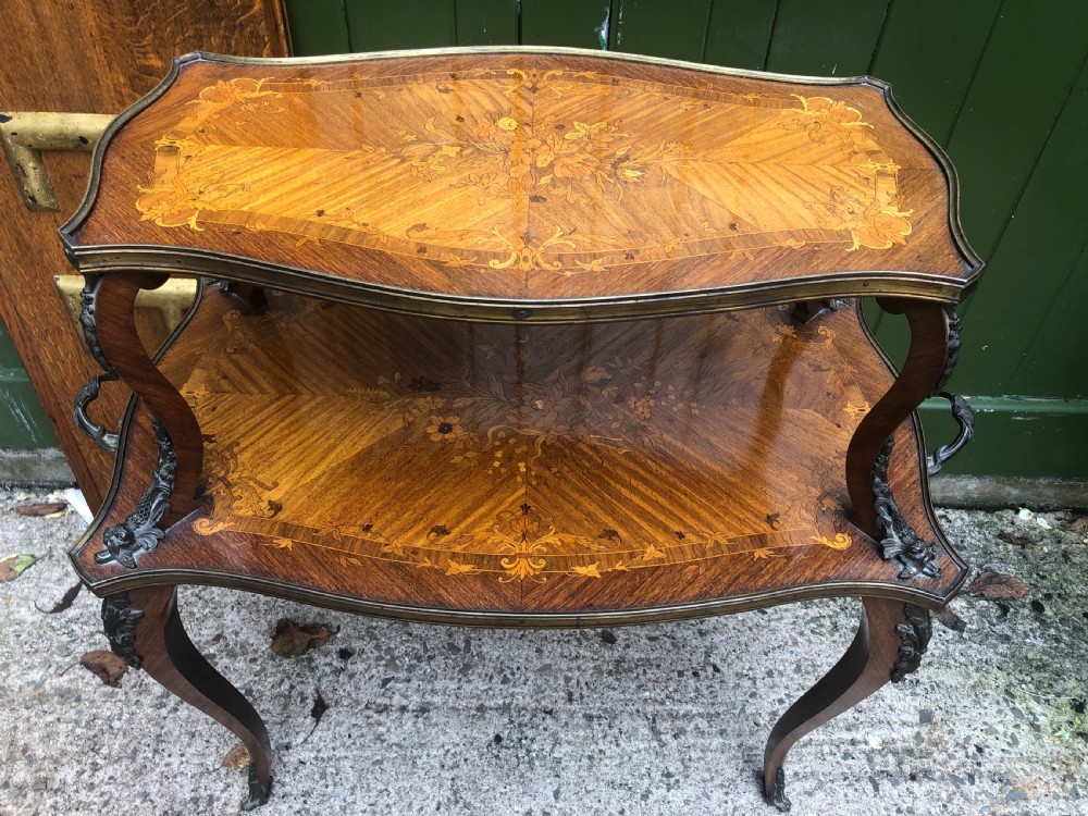 An early nineteenth-century French two-tier etagere table featuring detailed floral marquetry inlay, cabriole legs, brass galleries, and metal side handles. View VII