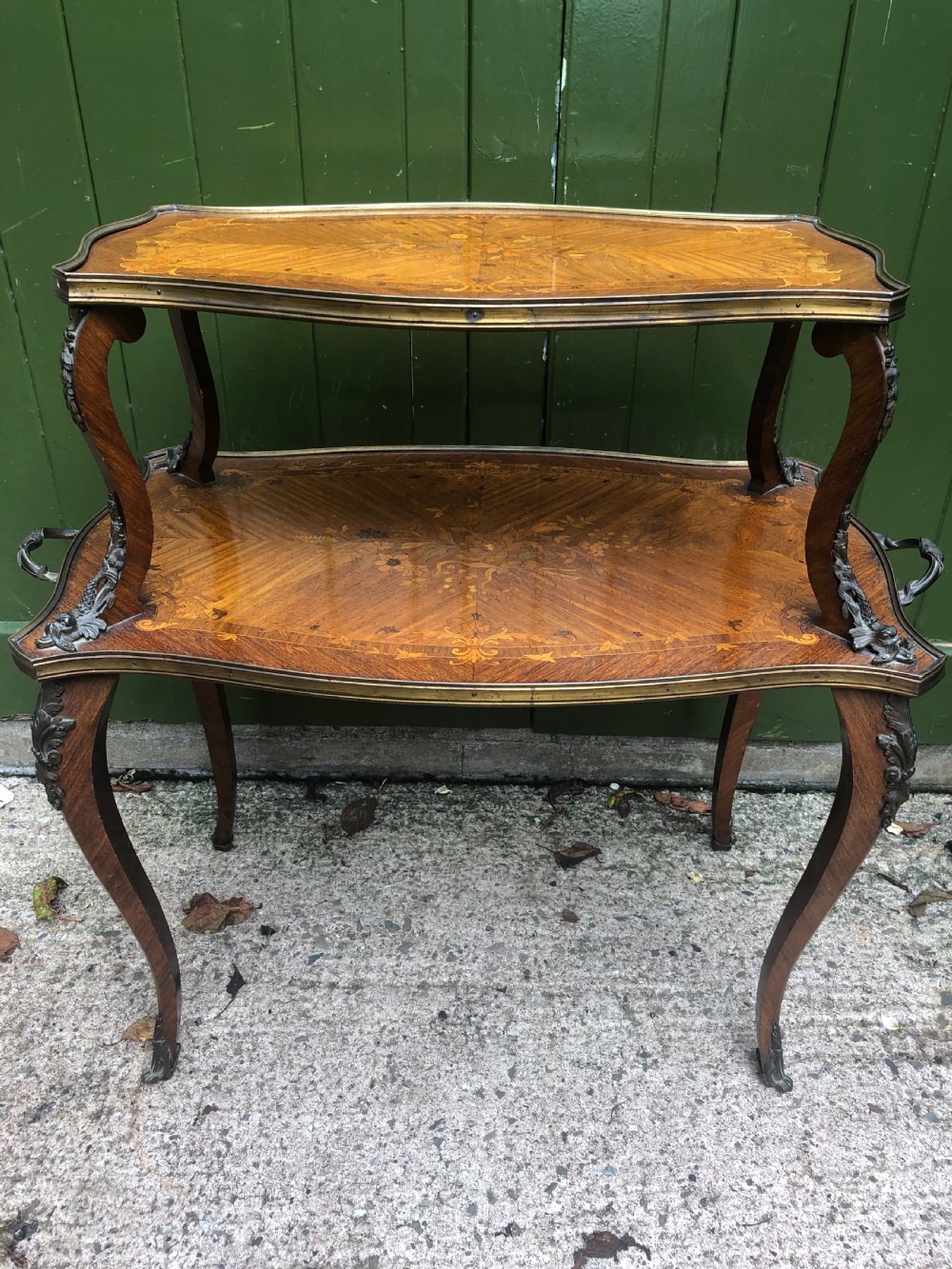 An early nineteenth-century French two-tier etagere table featuring detailed floral marquetry inlay, cabriole legs, brass galleries, and metal side handles. View IX