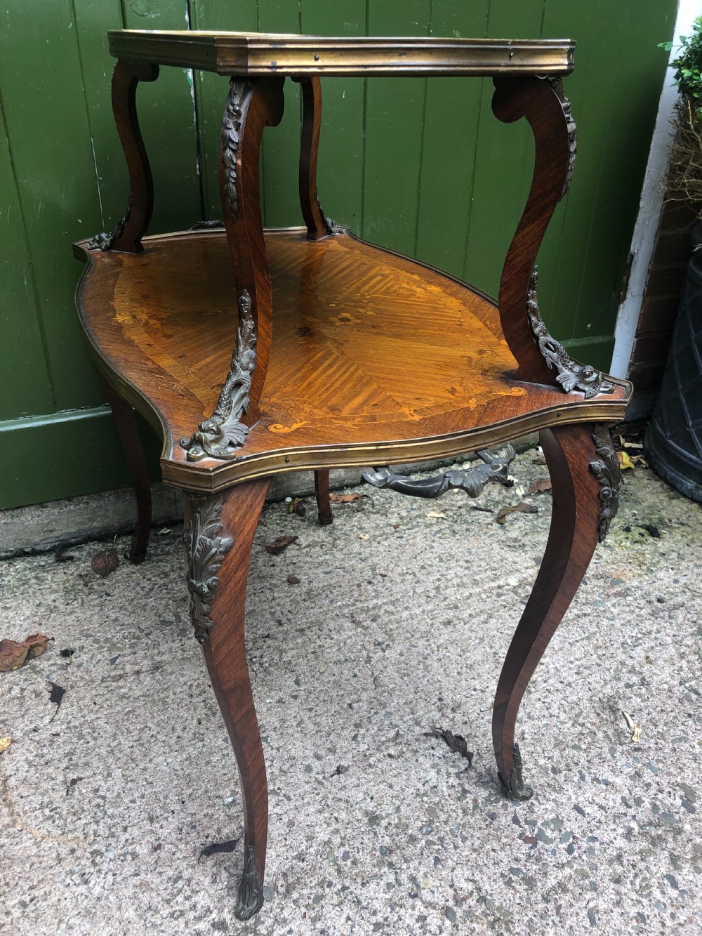 An early nineteenth-century French two-tier etagere table featuring detailed floral marquetry inlay, cabriole legs, brass galleries, and metal side handles. View XV
