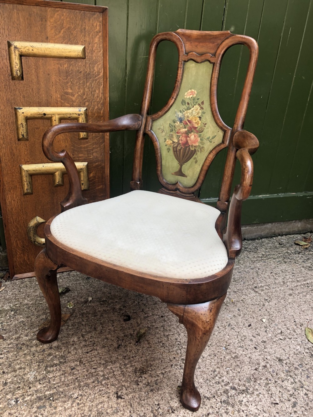 Early 20th-century Queen Anne revival walnut armchair featuring a painted floral splat back, carved armrests, cabriole legs, and cream upholstery. View II