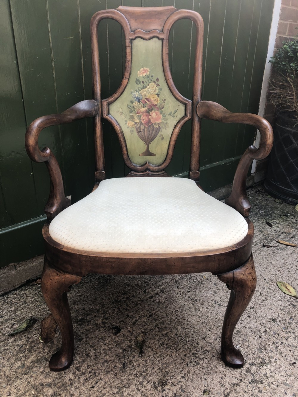 Early 20th-century Queen Anne revival walnut armchair featuring a painted floral splat back, carved armrests, cabriole legs, and cream upholstery. View IV