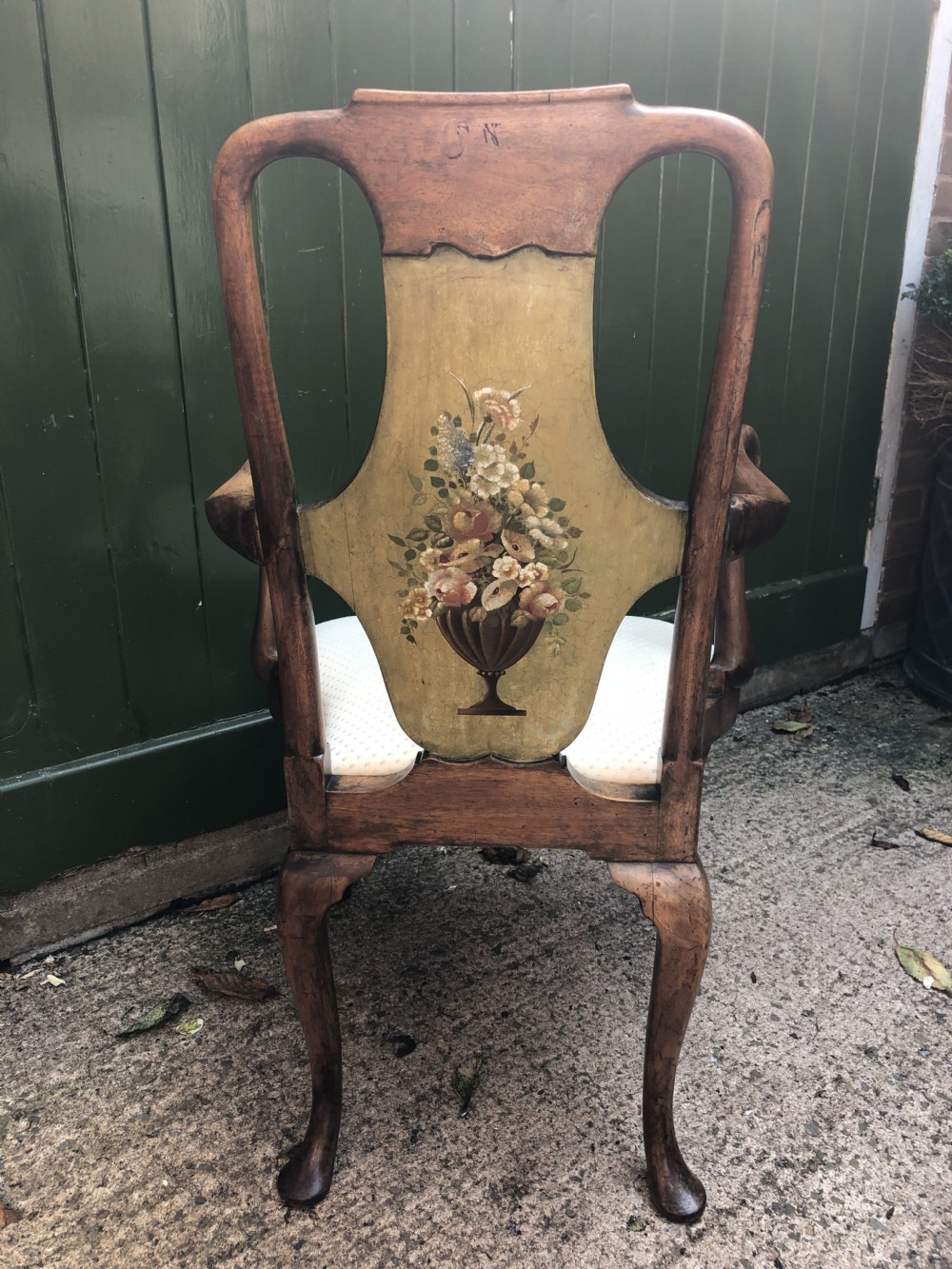Early 20th-century Queen Anne revival walnut armchair featuring a painted floral splat back, carved armrests, cabriole legs, and cream upholstery. View V