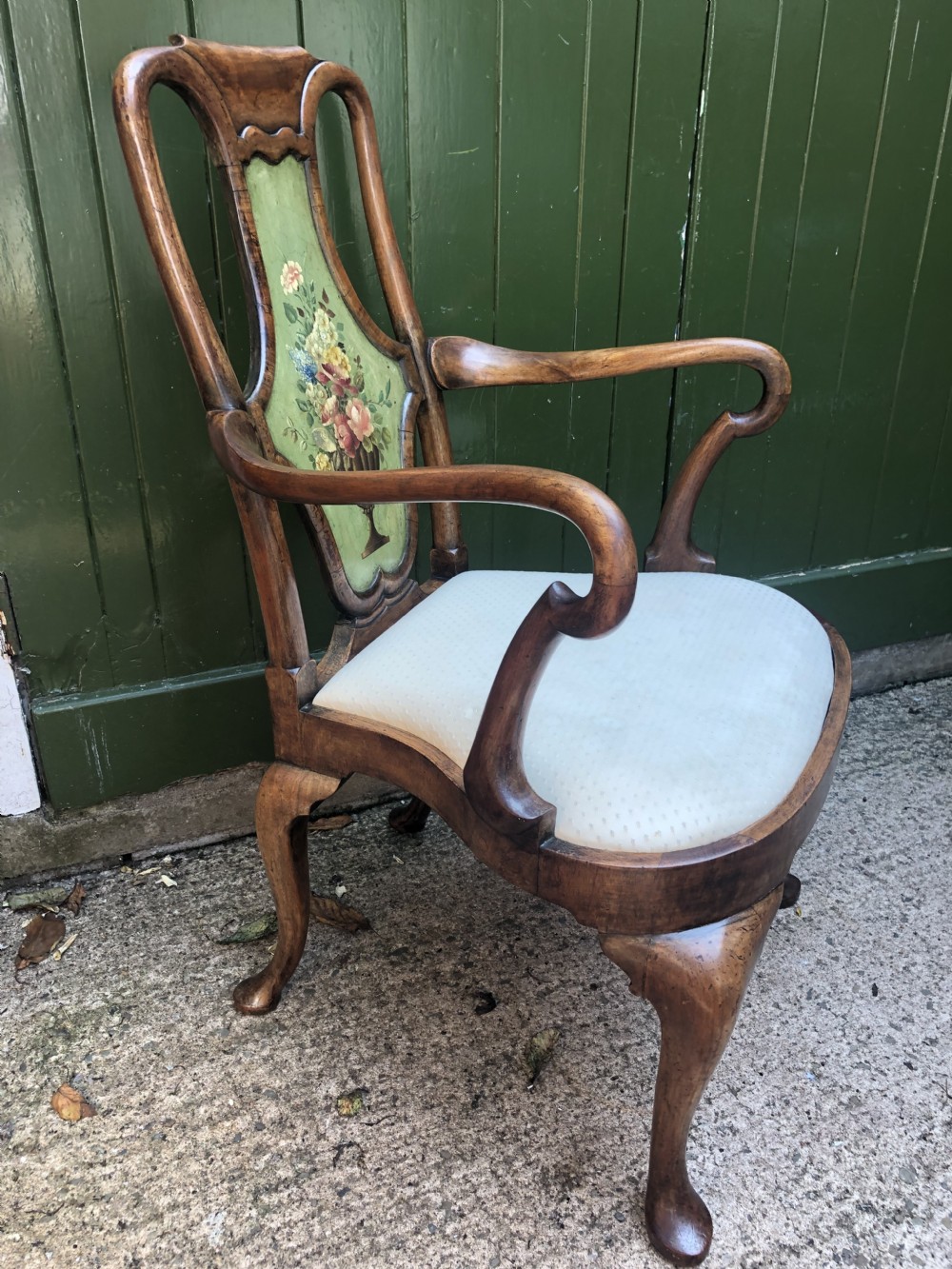 Early 20th-century Queen Anne revival walnut armchair featuring a painted floral splat back, carved armrests, cabriole legs, and cream upholstery. View VII