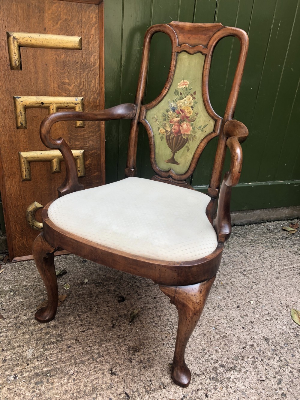 Early 20th-century Queen Anne revival walnut armchair featuring a painted floral splat back, carved armrests, cabriole legs, and cream upholstery. View XVII