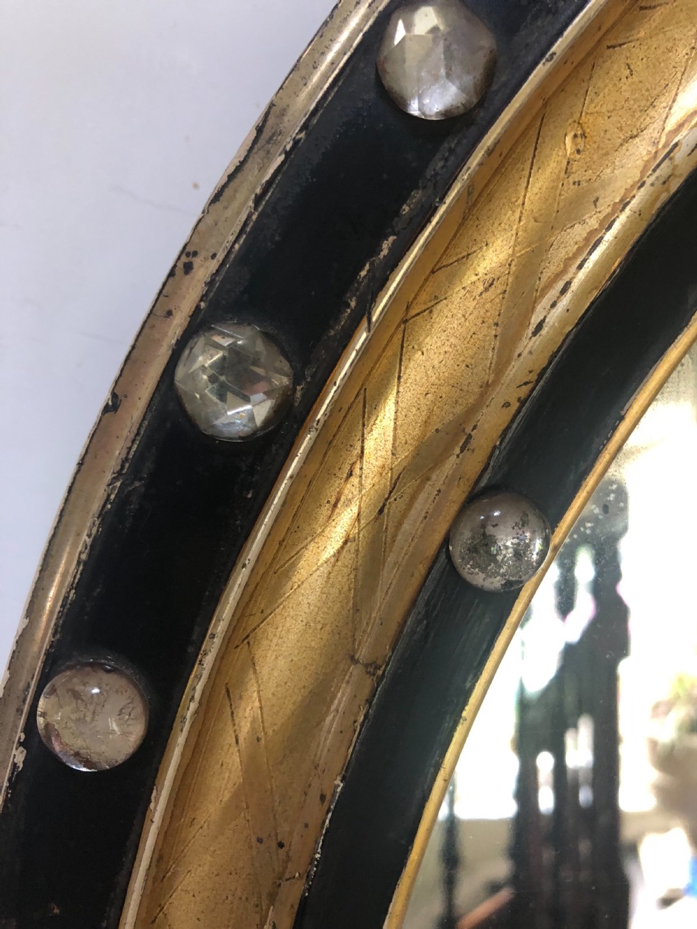 C19th Irish oval mirror with ebonised and gilded glass facet mounted frame with silvered outer edge . View IV