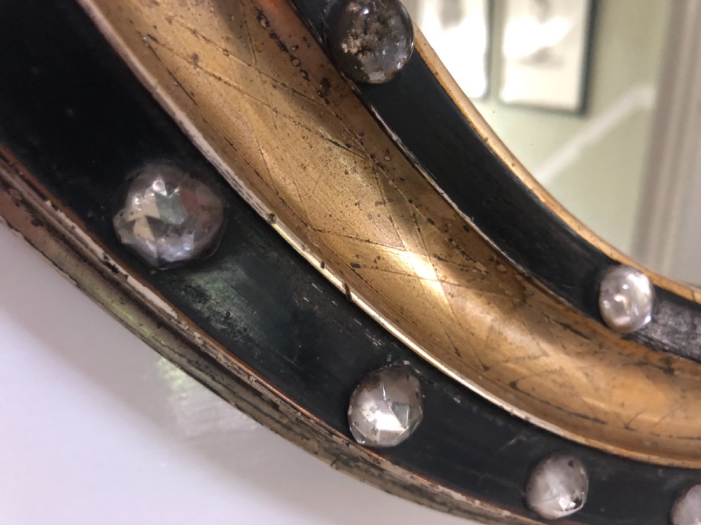 C19th Irish oval mirror with ebonised and gilded glass facet mounted frame with silvered outer edge . View VII