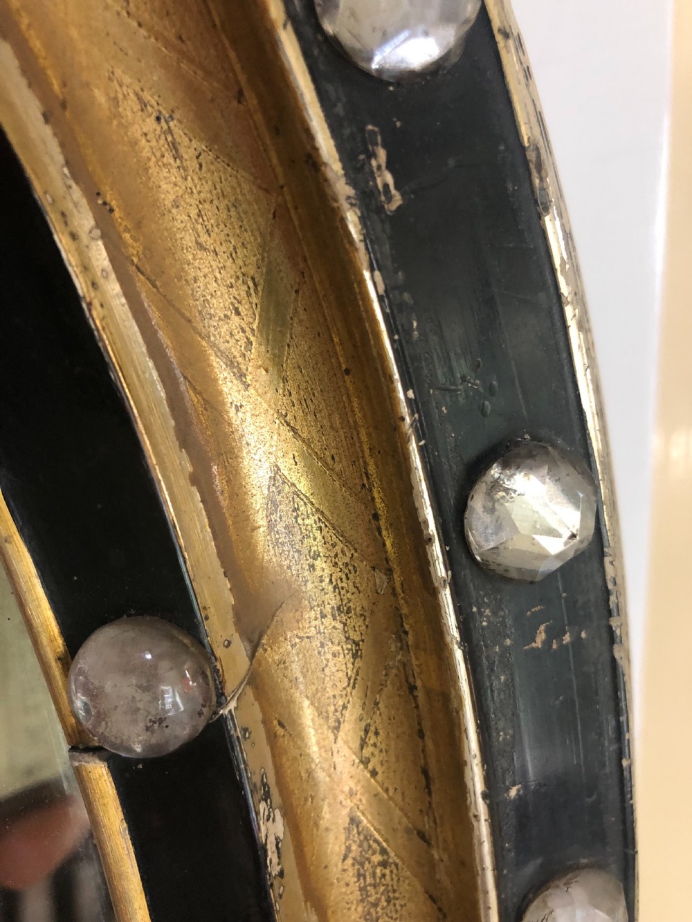 C19th Irish oval mirror with ebonised and gilded glass facet mounted frame with silvered outer edge . View VIII