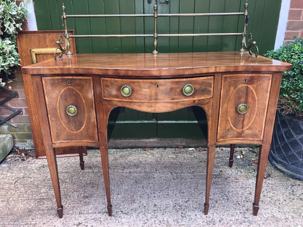 Fine late C18th George III Sheraton period mahogany serpentine front sideboard of compact proportions.