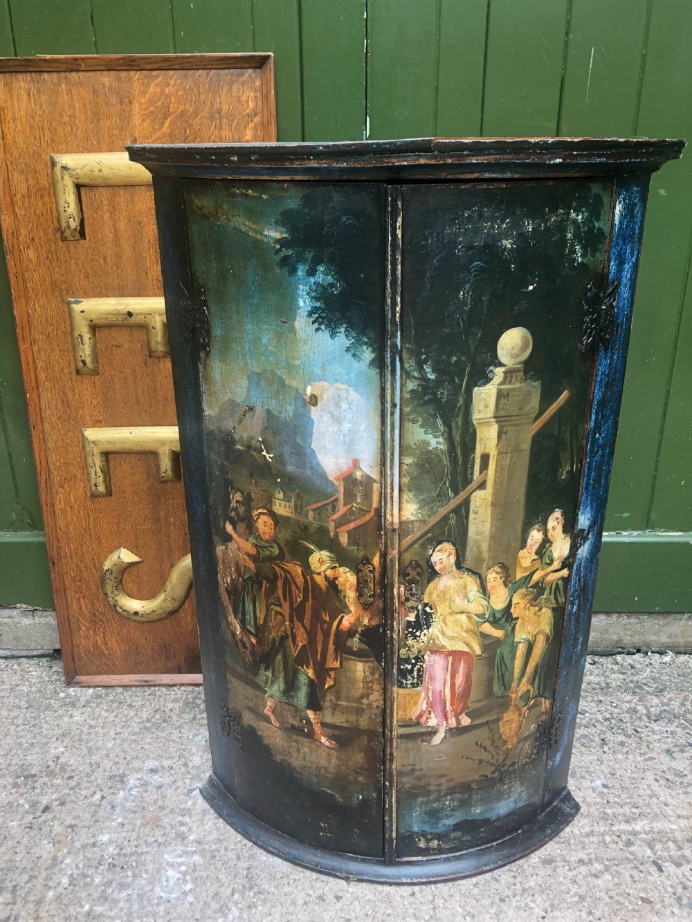 C18th Dutch bow-front hanging corner cupboard decorated with an exotic figural scene.