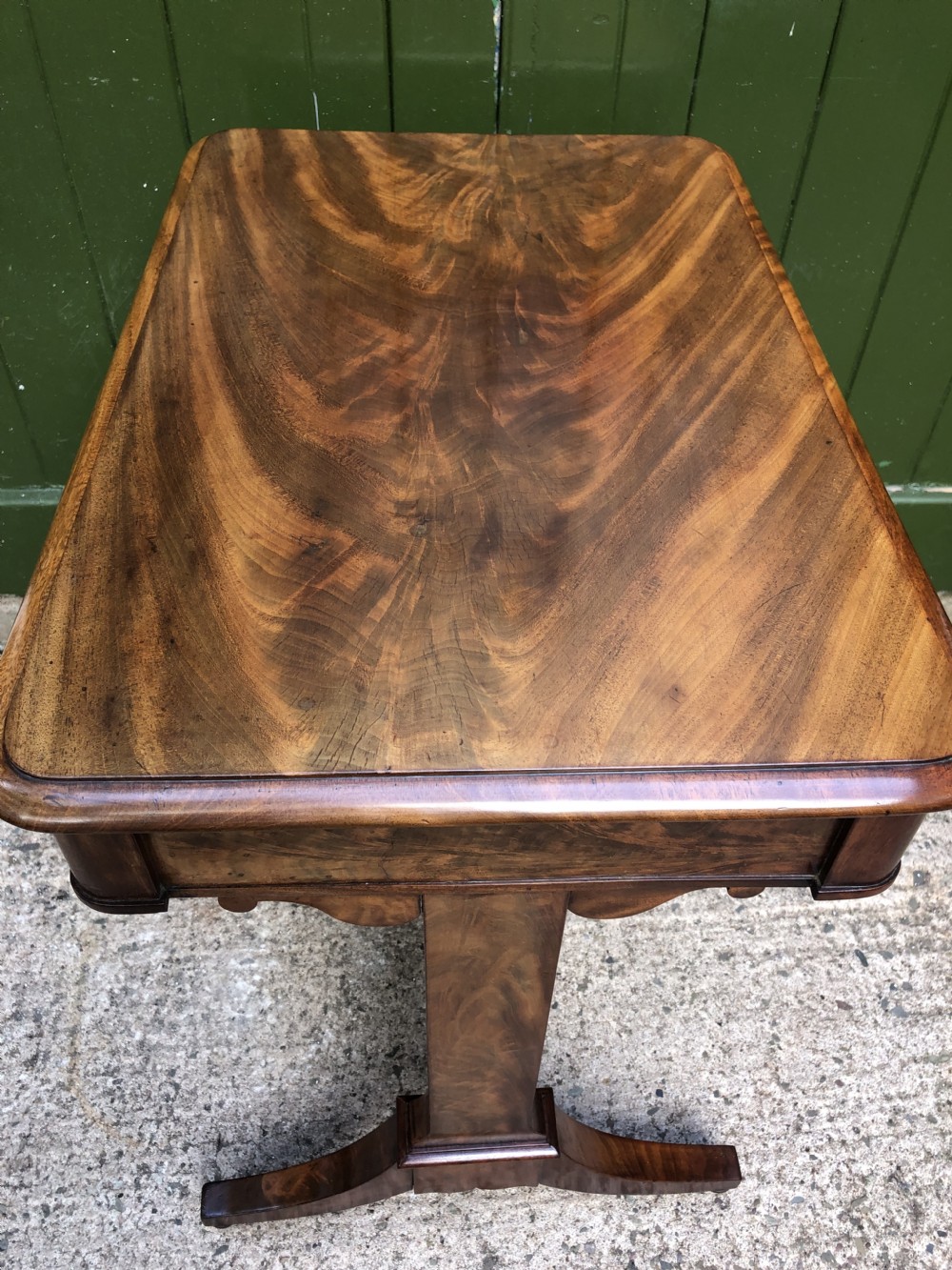 A George IV mahogany work table featuring a single drawer with turned knobs, a tapered lower well, carved trestle supports, and brass castors. View XX
