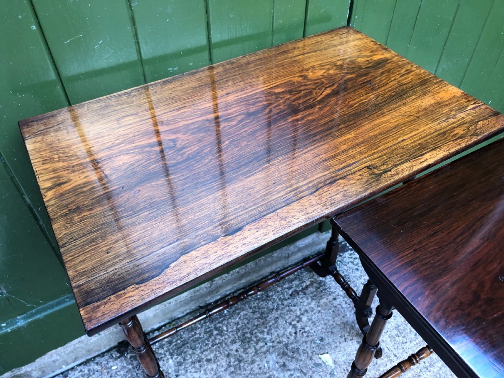 A set of three graduated Regency rosewood nesting tables featuring rectangular tops, slender turned spindle legs, and trestle bases. View VIII
