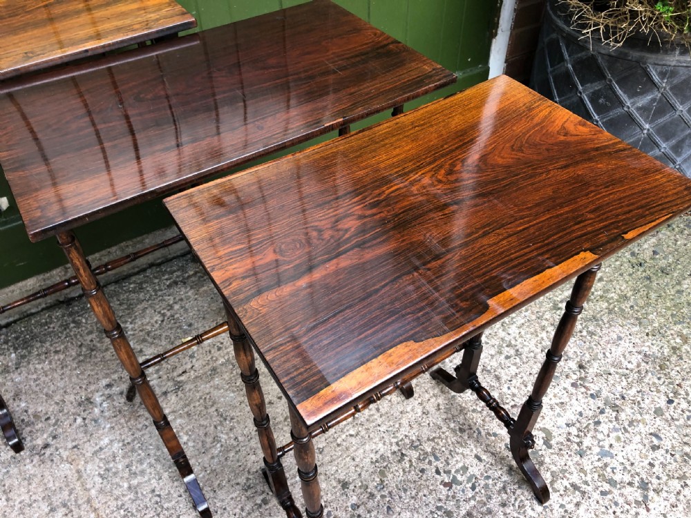 A set of three graduated Regency rosewood nesting tables featuring rectangular tops, slender turned spindle legs, and trestle bases. View IX
