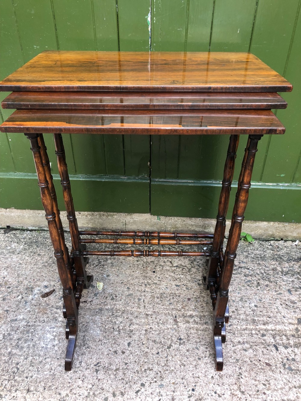 A set of three graduated Regency rosewood nesting tables featuring rectangular tops, slender turned spindle legs, and trestle bases. View XI
