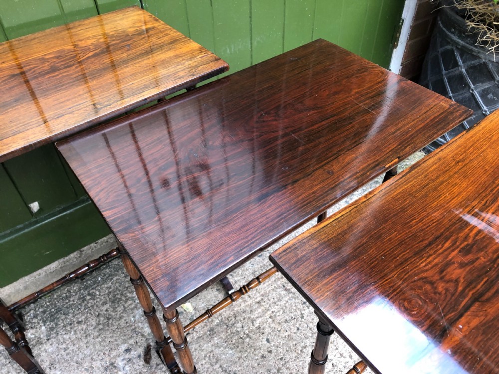 A set of three graduated Regency rosewood nesting tables featuring rectangular tops, slender turned spindle legs, and trestle bases. View XII