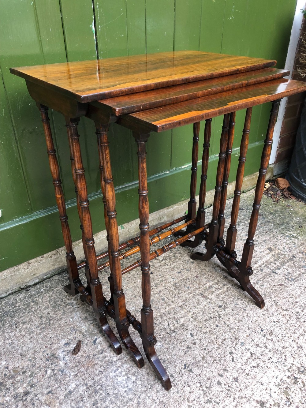 A set of three graduated Regency rosewood nesting tables featuring rectangular tops, slender turned spindle legs, and trestle bases. View XIII