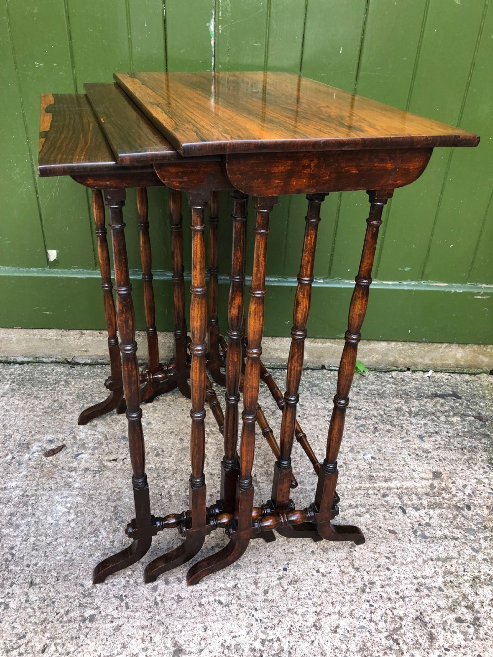 A set of three graduated Regency rosewood nesting tables featuring rectangular tops, slender turned spindle legs, and trestle bases. View XIV