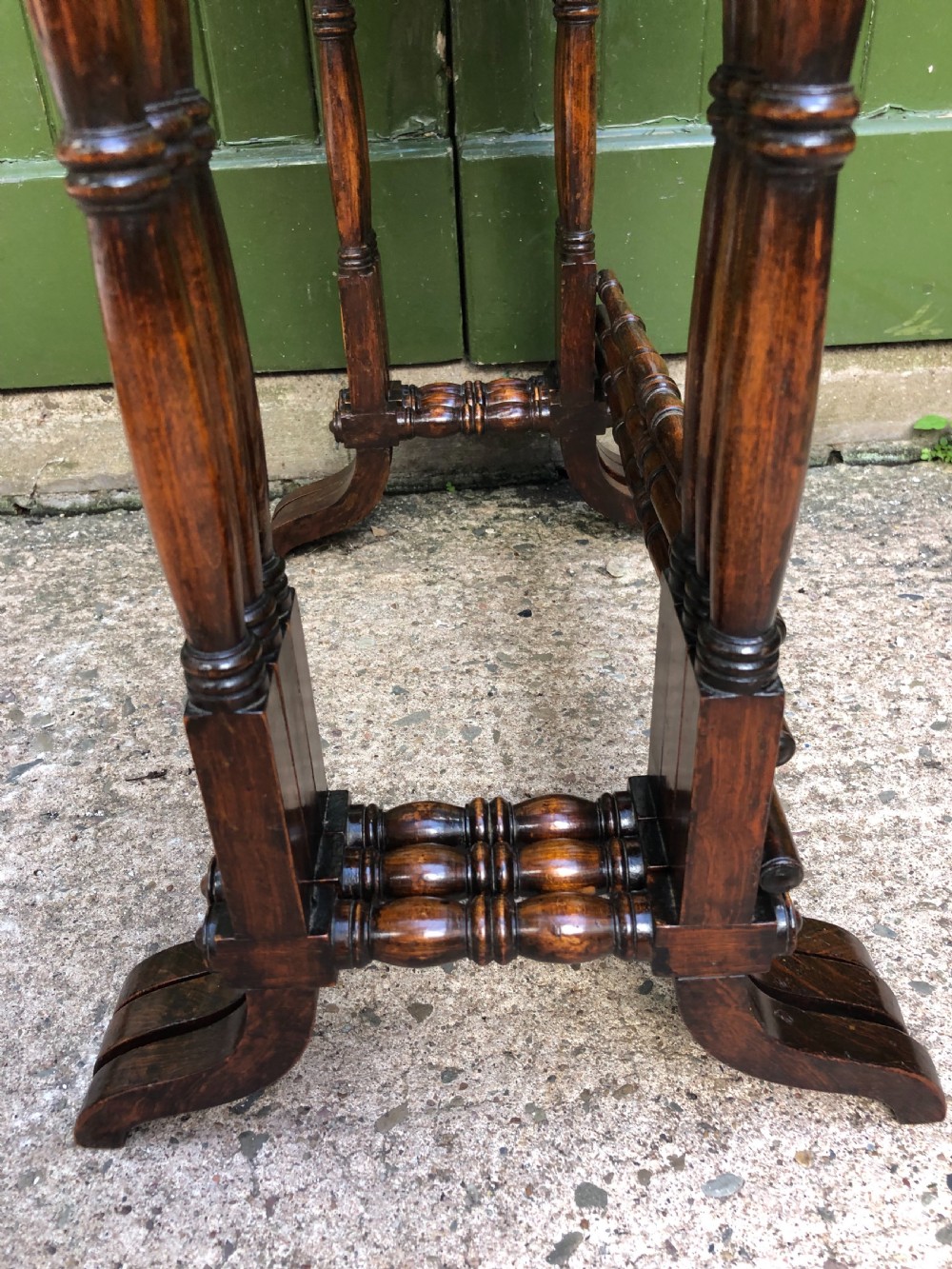A set of three graduated Regency rosewood nesting tables featuring rectangular tops, slender turned spindle legs, and trestle bases. View XV