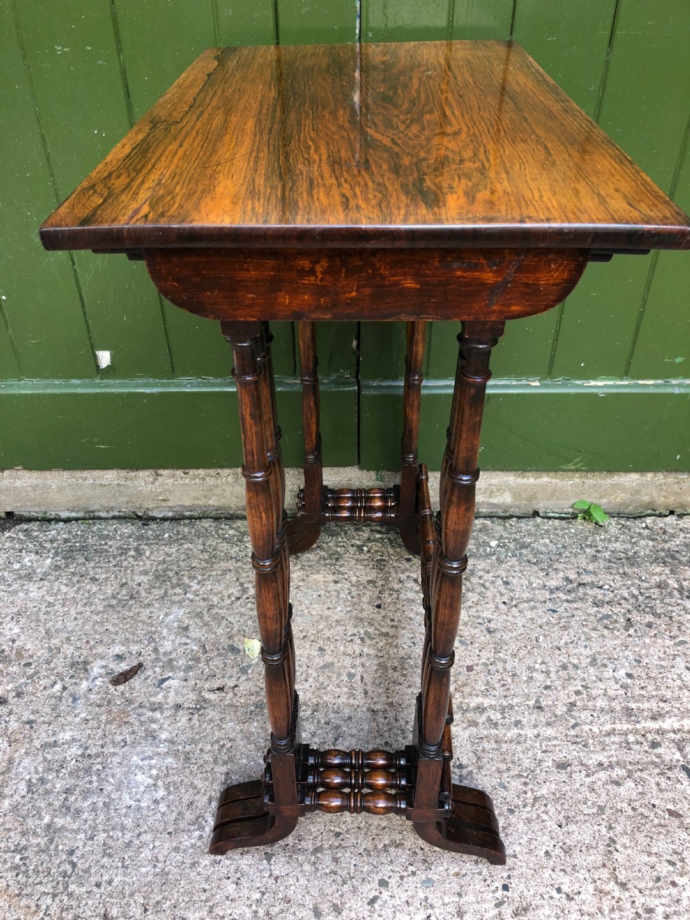 A set of three graduated Regency rosewood nesting tables featuring rectangular tops, slender turned spindle legs, and trestle bases. View XVI