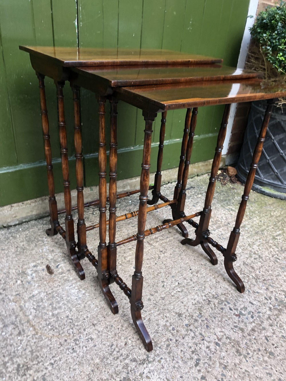 A set of three graduated Regency rosewood nesting tables featuring rectangular tops, slender turned spindle legs, and trestle bases. View XVIII
