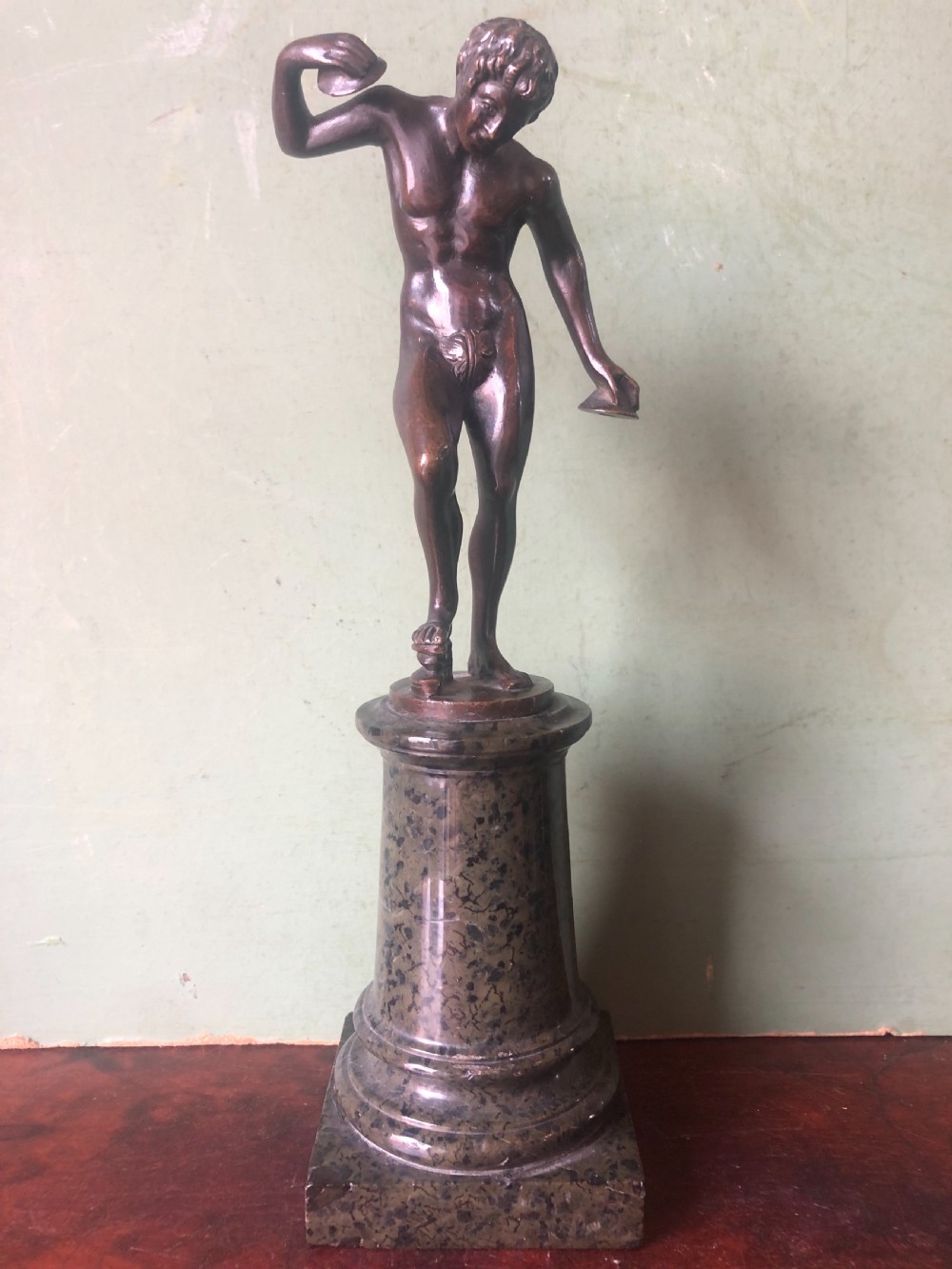 A pair of late nineteenth-century dark patinated bronze classical nude figures mounted on tall cylindrical dark marble column bases. View IV