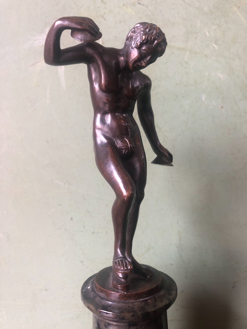 A pair of late nineteenth-century dark patinated bronze classical nude figures mounted on tall cylindrical dark marble column bases. View V