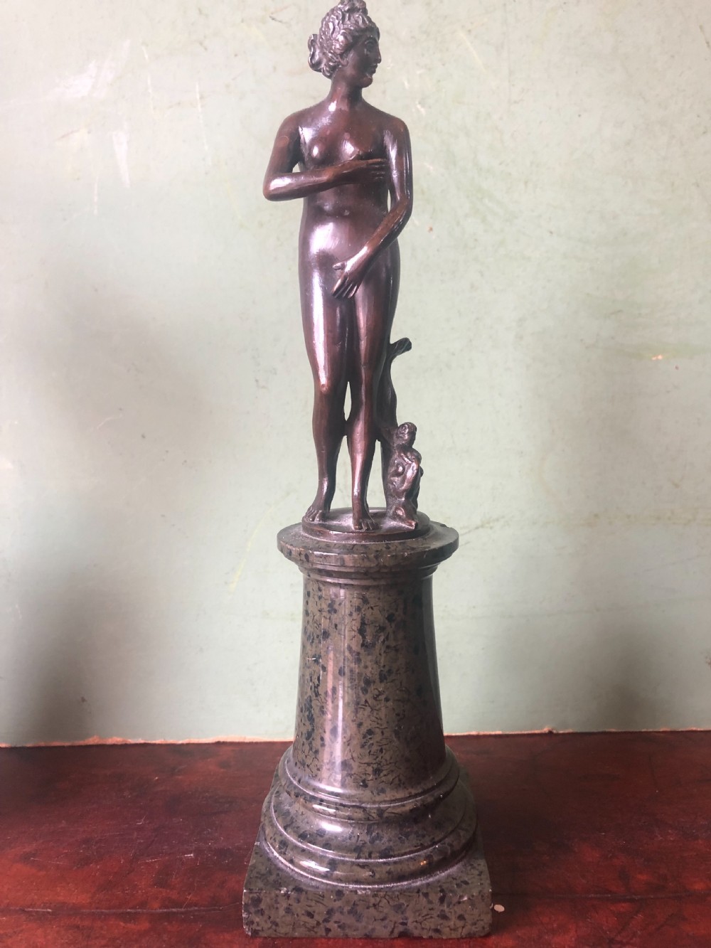 A pair of late nineteenth-century dark patinated bronze classical nude figures mounted on tall cylindrical dark marble column bases. View VI